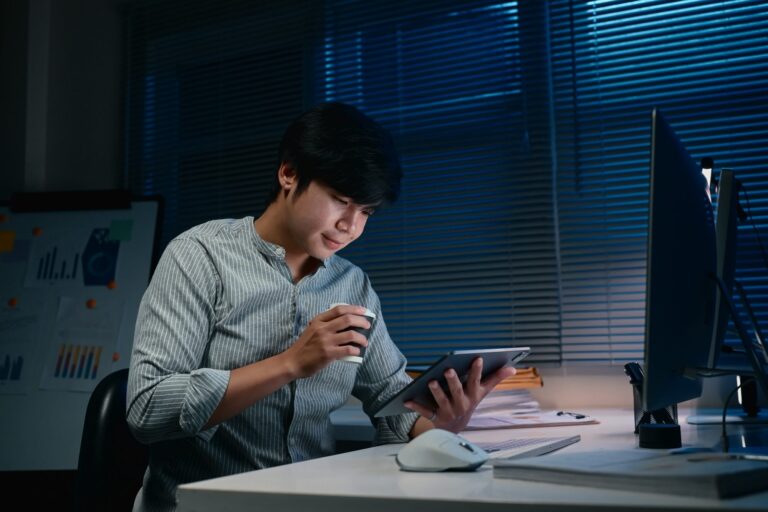 An office worker reviewing printed documents late in the evening