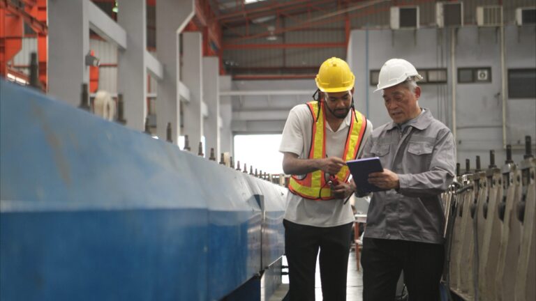 Two engineers inspecting machinery on a production line
